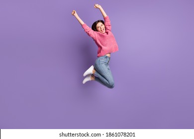 Full length body size photo of jumping high female student gesturing like winner overjoyed isolated on bright purple color background