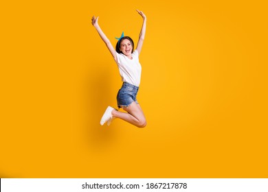 Full length body size photo of cheerful young woman jumping high smiling keeping hands over head isolated on vivid yellow color background