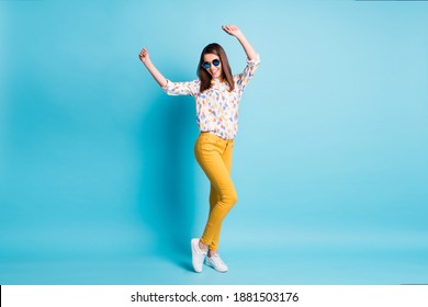 Full length body size photo of happy smiling girl dancing on dancefloor keeping hands up isolated on vibrant blue color background - Shutterstock ID 1881503176