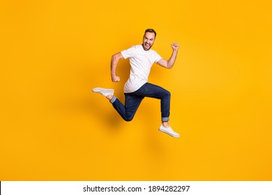 Full Length Body Size Photo Of Jumping Cheerful Male Model Wearing Stylish Outfit Isolated Vivid Yellow Color Background