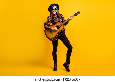 Full length body size photo of happy brunette playing acoustic guitar overjoyed isolated vibrant yellow color background - Powered by Shutterstock