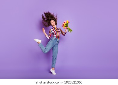 Full length body size photo of woman jumping gracefully keeping flowers smiling isolated vivid purple color background