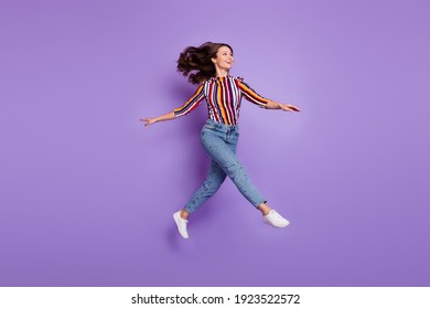 Full length body size photo of woman jumping up childish playful looking copyspace isolated vivid purple color background