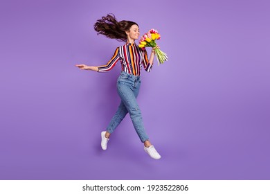 Full length body size photo of woman jumping high smelling tulip flowers scent isolated bright violet color background