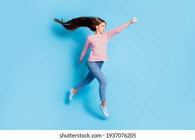 Full length body size photo serious powerful girl jumping imagine flying super woman isolated vivid blue color background