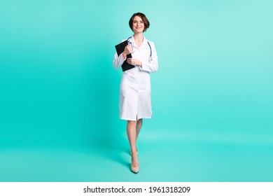 Full Length Body Size Photo Of Nurse Smiling Walking Forward Keeping Clipboard Isolated Vivid Teal Color Background