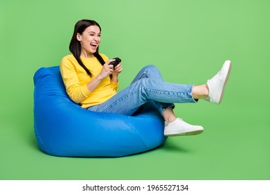 Full Length Body Size Photo Of Woman Sitting Beanbag Laughing Playing Video Game Isolated Vibrant Green Color Background