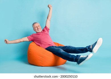 Full length body size photo elder man laying chilling on working break on beanbag overjoyed isolated pastel blue color background - Shutterstock ID 2000250110