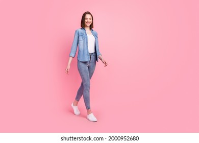 Full length body size photo girl smiling confident wearing stylish outfit walking forward isolated pastel pink color background