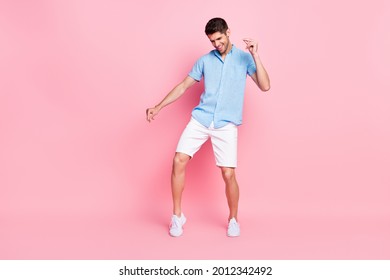 Full length body size photo smiling man in blue shirt dancing at party isolated pastel pink color background