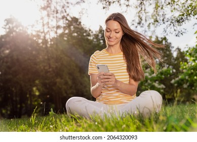 Full Length Body Size Photo Woman Sitting On Grass Smiling Happy Using Smartphone Browsing Internet