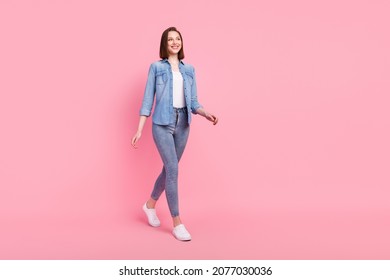 Full length body size photo girl smiling confident looking copyspace walking forward isolated pastel pink color background