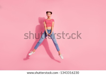 Full length body size photo shock beautiful she her lady pomade lips jump high legs separate big eyes not believe wear casual jeans denim striped red white t-shirt sit floor isolated pink background