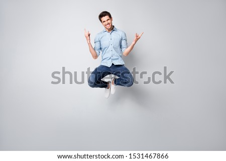 Full length body size photo of cheerful positive trendy ecstatic overjoyed rock fan showing you rock horned fingers signs jumping up at concert of his favorite band isolated over grey color background