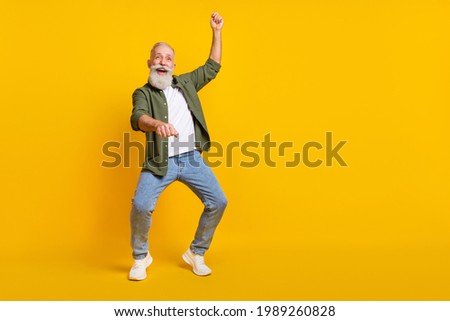 Full length body size photo of senior man crazy imagine riding horse on wild west isolated vivid yellow color background