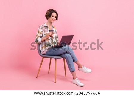 Full length body size photo woman working on laptop drikning coffee isolated pastel pink color background