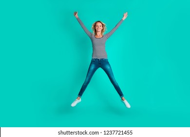 Full length body size portrait of nice attractive cheerful careless wavy-haired girl in striped pullover jeans denim flying up in air like star isolated over bright vivid shine turquoise background - Shutterstock ID 1237721455