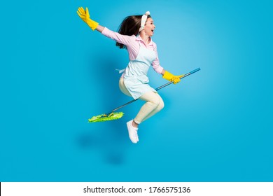 Full Length Body Size Profile Side View Of Her She Nice Attractive Funky Childish Comic Maid Jumping Riding Broom Like Horse Isolated On Bright Vivid Shine Vibrant Blue Color Background