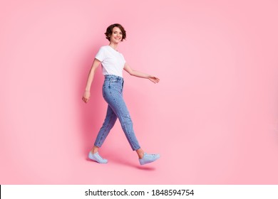 Full length body size profile side view of nice cheerful cheery brown-haired girl wearing comfy clothes walking isolated over pink color background - Shutterstock ID 1848594754