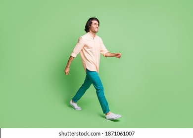 Full Length Body Size Profile Side View Of Nice Cheery Guy Wearing Casual Clothes Walking Isolated Over Bright Green Color Background