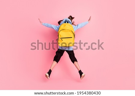 Full length body size rear back behind view of nice girl jumping new academic school year isolated over pink pastel color background