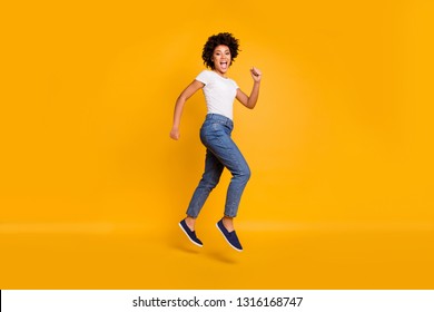 Full length body size side profile photo jumping high beautiful she her lady rushing shopping big shopper mall store wearing casual jeans denim white t-shirt clothes isolated yellow background