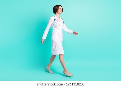 Full Length Body Size Side Profile Photo Female Doctor Walking Forward Wearing White Uniform Smiling Isolated Bright Teal Color Background