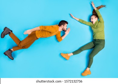 Full Length Body Size Top Above High Angle View Photo Of Woman Being Blown Away With Gust Of Wind Created By Her Husband Screaming On Face Isolated Pastel Color Blue Background