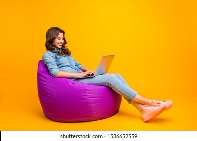 Full Length Body Size Turned Photo Of Cheerful Positive Cute Nice Attractive Blogger Browsing Through Her Laptop In Search Of New Information Isolated Over Yellow Vibrant Color Background