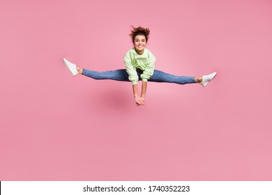 Full length body size view of her she nice attractive perfect shape athletic cheerful cheery energetic girl jumping doing twine practicing isolated over pink pastel color background - Powered by Shutterstock