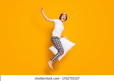 Full Length Body Size View Of Her She Nice Attractive Crazy Funky Cheerful Cheery Girl Jumping Having Fun Riding White Pillow Like Horse Isolated Bright Vivid Shine Vibrant Yellow Color Background