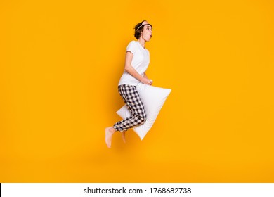 Full Length Body Size View Of Her She Nice Attractive Crazy Foolish Cheery Girl Jumping Having Fun Riding White Pillow Like Horse Rider Isolated Bright Vivid Shine Vibrant Yellow Color Background