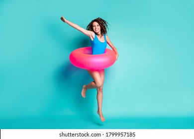 Full length body size view of her she attractive cheerful slender pretty girl jumping wearing swimwear pink safety buoy active life isolated bright vivid shine vibrant blue color background
