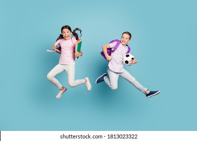 Full length body size view of his he her she nice attractive small little cheerful friends friendship jumping playing football cup goal after classes lesson isolated blue pastel color background - Powered by Shutterstock