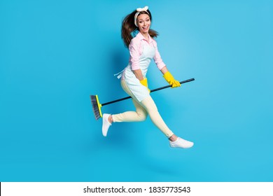 Full Length Body Size View Of Her She Nice Attractive Pretty Cheerful Cheery, Glad Girl Maid Jumping Riding Broom Like Horse Having Fun Isolated Over Bright Vivid Shine Vibrant Blue Color Background