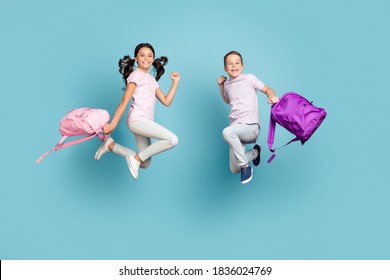 Full Length Body Size View Of His He Her She Nice Attractive Small Little Cheerful Buddy, Fellow Jumping Having Fun After Classes Leisure Autumn Fall Season Isolated Blue Pastel Color Background