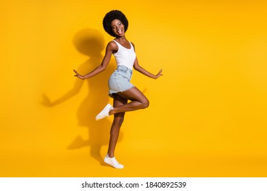 Full length body size view of pretty cheerful wavy-haired lady jumping dancing having fun isolated over bright yellow color background