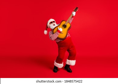 Full length body size view of his he handsome bearded fat overweight Santa grandfather soloist playing guitar having fun vocal talent leisure isolated bright vivid shine vibrant red color background - Powered by Shutterstock