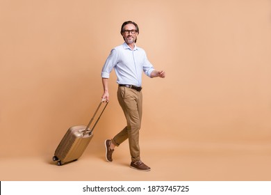 Full Length Body Size View Of Nice Classy Cheerful Man Going Departure Carrying Bag Isolated Over Beige Pastel Color Background