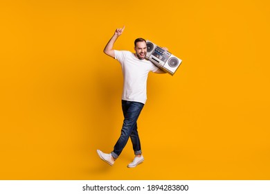 Full length body size view of attractive cheerful carefree guy dancing carrying player isolated over bright yellow color background - Shutterstock ID 1894283800