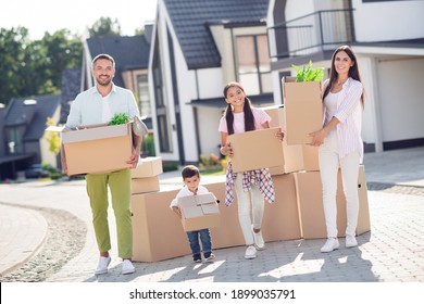 Full Length Body Size View Of Four Nice Cheery People Small Little Kids Brother Sister Carrying Boxes Moving New Residence Town City Rent Lease