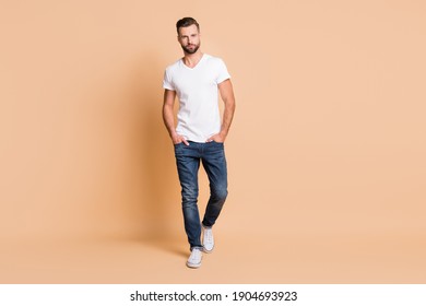 Full length body size view of nice content attractive tall macho guy going isolated over beige pastel color background - Shutterstock ID 1904693923
