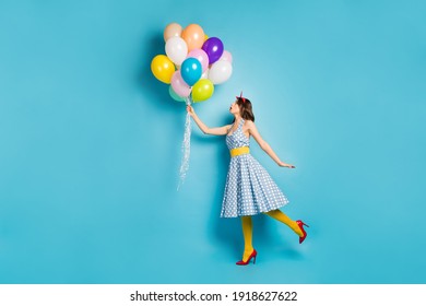 Full length body size view of her she nice attractive dreamy fashionable wavy-haired girl holding air balls flying up walking having fun isolated on bright vivid shine vibrant blue color background