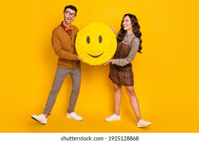 Full length body size view of attractive cheerful couple holding in hands paper emoji having fun isolated on bright yellow color background - Powered by Shutterstock