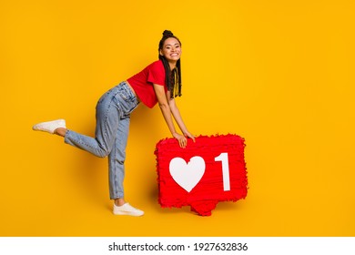 Full length body size view of lovely cheerful girl holding in hands big board heart influenzer isolated bright yellow color background