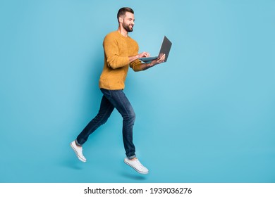 Full length body size view of nice cheerful skilled focused guy jumping going using laptop isolated over bright blue color background - Shutterstock ID 1939036276