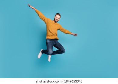 Full length body size view of attractive cheerful guy jumping having fun like plane isolated on bright blue color background - Shutterstock ID 1949653345