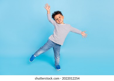 Full length body size view of nice cheerful boy dancing having fun isolated over bright blue color background