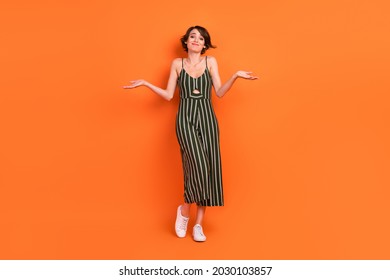 Full Length Body Size View Of Attractive Cheery Clueless Girl Shrugging Shoulders Isolated Over Bright Orange Color Background