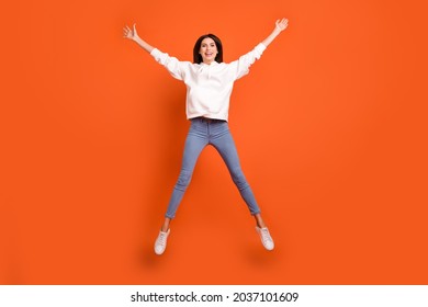 Full length body size view of pretty carefree cheerful girl jumping having fun isolated over bright orange color background - Shutterstock ID 2037101609